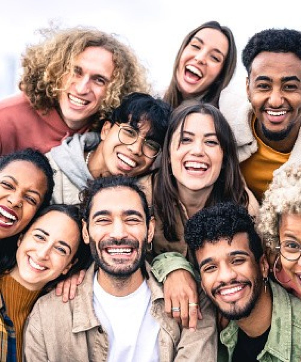 Multi ethnic guys and girls taking selfie outdoors with backlight - Happy life style friendship concept on young multicultural people having fun day together in Barcelona - Bright vivid filter